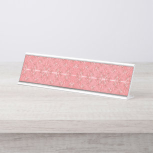 Ein Teppich mit roten und rosa Motiven ist mit ein Schreibtischnamensplakette