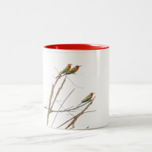 Ein Trio Bienen fängt an den Limben. Zweifarbige Tasse
