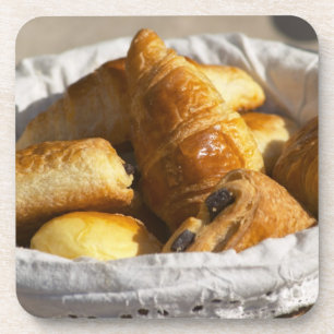 Ein Weiden-Frühstückskorb mit Croissants und Untersetzer