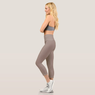 eine braune Mauer mit einer Uhr darauf Capri Leggings