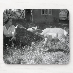 Eine Frau füttert eine Antilope mit der Flasche. Mousepad