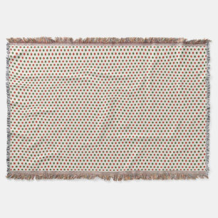 Eine gewebte Decke mit roten und grünen Tupfen 