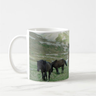 EINE GRUPPE VON PFERDEN AUF EINER BERGSTUFE KAFFEETASSE
