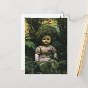 Eine gruselige verlassene Puppe im Wald Postkarte