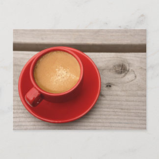 Eine helle rote Tasse Espressokaffee auf einem Pic Postkarte