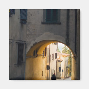 Eine Person, die unter einem Bogen geht, einen Hü Magnet