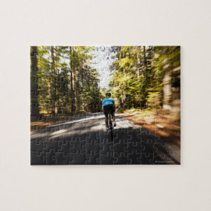 Eine Radlerin fährt schnell auf einer kleinen schm Puzzle