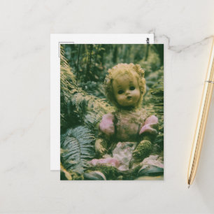 Eine verlassene Puppe im Wald Postkarte