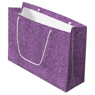 Eine violette Geschenktüte mit Glitter und einem w