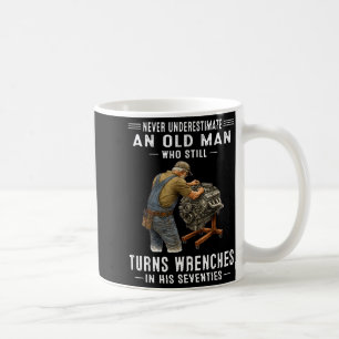 Einen alten Mann, der Schraubenschlüssel dreht, un Kaffeetasse