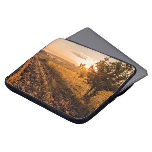 Einmaliger Baum auf dem nebeligen Feld im goldenen Laptopschutzhülle