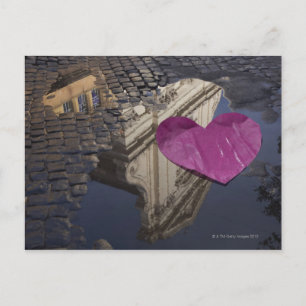 Einmaliges Papierherz schwebt in einer Pfütze. Postkarte