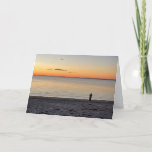 Einsame Figur, die auf dem Ozeanstrand steht Foto Karte