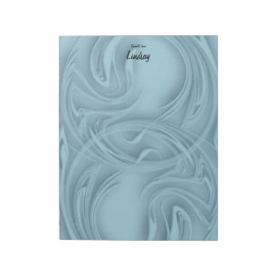 Elegante Anschläge über blauem abstraktem Notizblock