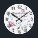 Elegante florale Hochzeit Soft Botanical Romance Runde Wanduhr<br><div class="desc">Dieses elegante Design besticht durch eine anmutige Anordnung von handbemalten Blumenelementen in sanften Pastelltönen. Das Design zeigt zarte weiße Knospen, sanfte blaue Blüten und eine pulsierende magnolische Blume, alles Set vor einem weichen grauen Hintergrund. Die minimalistischen Blumenakzente verleihen dem Ganzen ein Gefühl zeitloser Schönheit und Romantik, perfekt für Paare, die...</div>