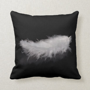 Elegante weiße Feder auf einem schwarzen Kissen