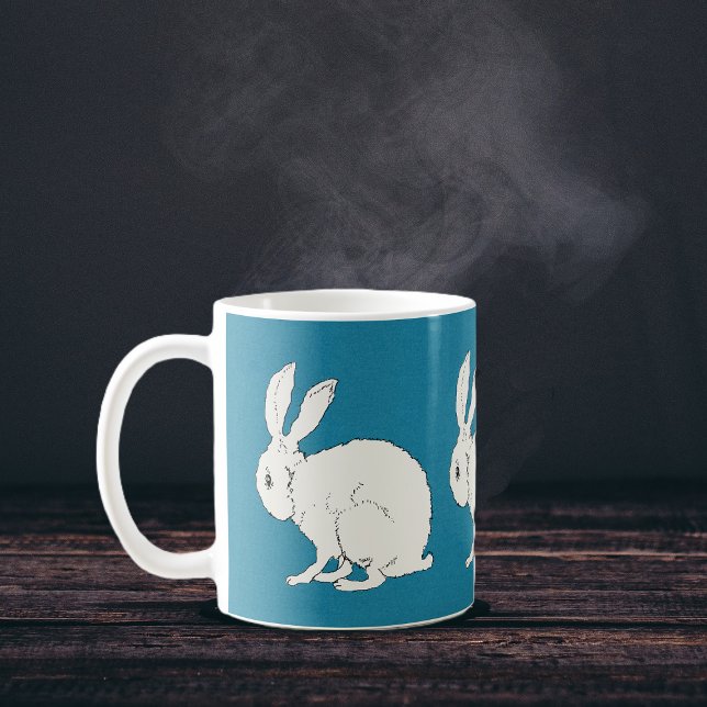 elegante, weiße Hasen auf blau Kaffeetasse (Simple white sitting rabbits on dark blue circling a coffee or tea mug.)