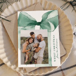 Elegantes Green Watercolor Bow 3 Foto Feiertagskarte<br><div class="desc">Feiern Sie die Saison mit dieser eleganten Weihnachtskarte, die einen atemberaubenden grünen Aquarellbogen mit weißem Hintergrund aufweist. Personalisieren Sie das Design, indem Sie Ihr vertikales Foto in einem einzigartigen Offset-Layout hinzufügen. Ihr Urlaubsgruß wird in klassisch grüner Serifenschrift gezeigt, begleitet von Ihrem Familiennamen in einem eleganten, handgeschriebenen Skript. Mit Platz für...</div>