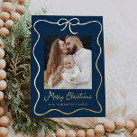 Elegantes Navy- und Gold Ribbon Bow 2 Foto Folien Feiertagskarte<br><div class="desc">Feiern Sie die Saison mit unserer eleganten Navy und Gold Foil Ribbon Bow 2 Foto Holiday Card. Dieses charmante Design zeigt Ihr gepflegtes Foto, umgeben von einem festlichen vergoldeten Band-Rahmen mit einem Bogen oben. Der Marinehintergrund unterstreicht wunderbar den handgeschriebenen "Frohen Weihnachten" Gruß in Goldfolienskript, der mit einem Gruß Ihrer Wahl...</div>