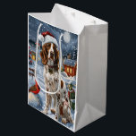 English Setter Winter Wonderland Christmas Joy Mittlere Geschenktüte<br><div class="desc">Dieses festliche Design spiegelt den fröhlichen Geist der Urlaubssaison wider und besticht durch ein hübsches Jungtier mit einer Weihnachtsmannmütze. Der Hund ist eingebettet in ein winterliches Wunderland, mit einem Schneemann, einem dekorierten Weihnachtsbaum und wunderschön verpackten Geschenken. Schneeflocken fallen sanft ab und geben der Szene eine magische Touch, während die lebhaften...</div>