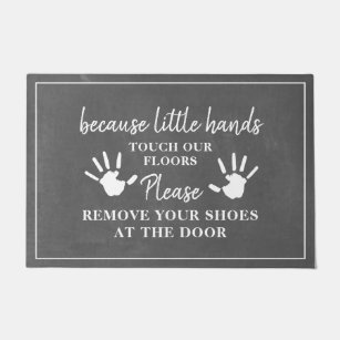 Entfernen Sie die Schuhe mit kleinen Handschuhen Fußmatte