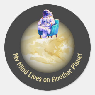 Entspannter Astronaut sitzt auf einem Planeten  Runder Aufkleber