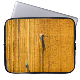 Erntemaschine arbeitet auf dem Feld. Mähdrescher Laptopschutzhülle