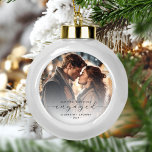 Erste Weihnachten Verlobte Custom Foto Grau Script Keramik Kugel-Ornament<br><div class="desc">Gedenken Sie Ihre Verlobung mit diesem schönen modernen Sakraldekor. Der kohlegraue Text lautet "Unser erstes Weihnachtsfest verlobt", mit dem Wort "verlobt" in eleganter Schrift, die vor und nach den Wimpern schwebt. Ersetzen Sie das Beispielbild durch Ihr Lieblings-Foto, und fügen Sie Ihre Namen und das Jahr hinzu. Mithilfe eines Farbverlaufsefilters wird...</div>