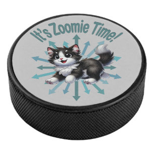 Es ist Zoomie-Zeit Süße Schwarz-Weiß-Katze Eishockey Puck