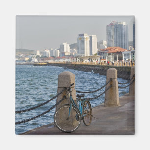 Fahrrad am Wasser mit der Skyline der Stadt Yantai Magnet