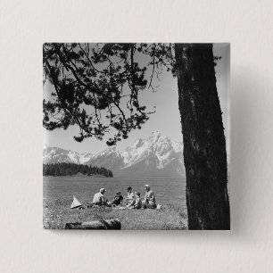 Familie, die Picknick durch Seeberge hat Button