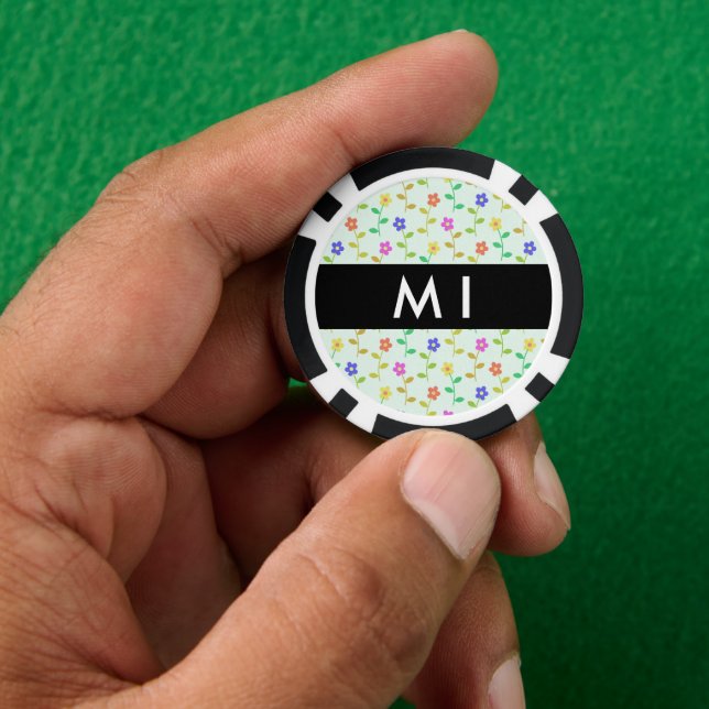 Farbenfrohe Blume, hellgrüner Hintergrund, schwarz Pokerchips (Hand)