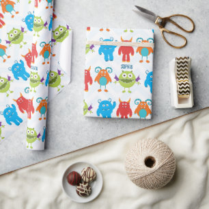 Farbenfrohe glückliche Monster mit Kid Name Patte Geschenkpapier