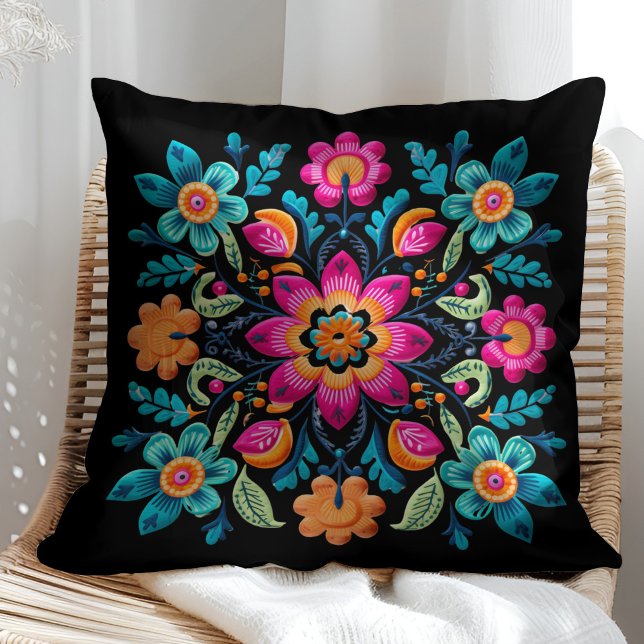 Farbenfrohe mexikanische Floral Fiesta Patter Kissen (Colorful Mexican Floral Fiesta Patter Throw Pillow on a sunny rattan chair.)