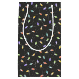 Farbenfrohe Weihnachtslichter auf schwarzem Gewand Kleine Geschenktüte