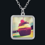 Farbenfroher Cupcake mit Cherry oben Versilberte Kette<br><div class="desc">Ein helles sommerliches Foto eines köstlichen Kuchens. Dieses Bild hat weiße flauschige Wolken und Berge im Hintergrund. Der leckere Kuchen ist in einem hellrosa und lila roten Wrapper enthalten. Der Cupcake selbst ist eine Kombination aus Vanillekuchen und Schokoladeneis mit einer saftigen Kirsche oben mit einem langen roten Stamm. Der Cupacake...</div>