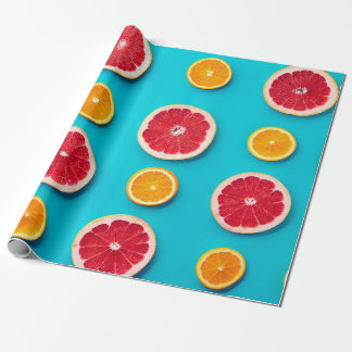 Farbenfrohes Fruchtmuster aus frischer Orange und Geschenkpapier