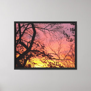 Farbenprächtiger Sonnenuntergang durch kahle Bäume Leinwanddruck