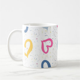 Farbige Herzchen und gesprenkelter Kaffeebecher mi Kaffeetasse