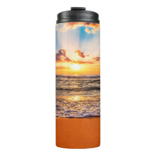 Farbiger Meerestrand Sonnenaufgang mit tiefblauem Thermosbecher