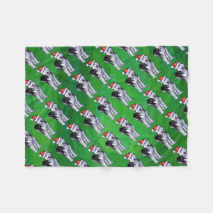 Feiernder Husky in Weihnachtsmannmütze auf Green Fleecedecke