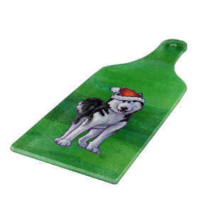 Feiernder Husky in Weihnachtsmannmütze auf Green Schneidebrett