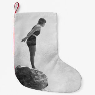 Female swimmer on rock above crashing surfvintage, kleiner weihnachtsstrumpf