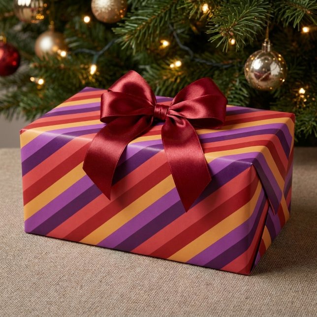 Fette Retro-Rot-Lila-Gold-Streifen Geschenkpapier (Bold Retro Red Purple Gold Stripes Wrapping Paper wrapped around a present under a Christmas tree.)
