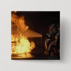 Feuerwehrleute löschen eine simulierte Batterie Button