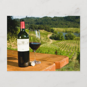 Flasche Rotwein und Glas auf dem Tisch Postkarte