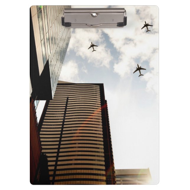 Flugzeuge, die über Gebäude fliegen Klemmbrett (Vorderseite)