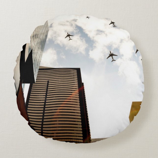 Flugzeuge, die über Gebäude fliegen Rundes Kissen (Vorderseite)