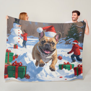 Französische Bulldogge läuft im Schnee mit Weihnac Fleecedecke