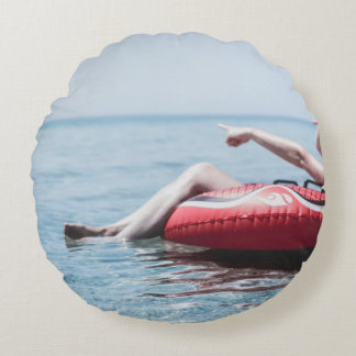 Frau auf einem aufblasbaren Schwimmer im Ozean, de Rundes Kissen